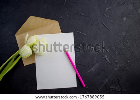Blank white postcard flyer. Envelope kraft whith pensil and tulips. Flat lay