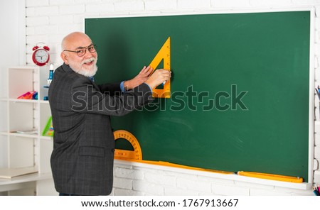 tutor man in glasses draw with triangle on blackboard. back to school. what angle you look. geometric shapes. high school modern education. senior man teacher use triagle while drawing.