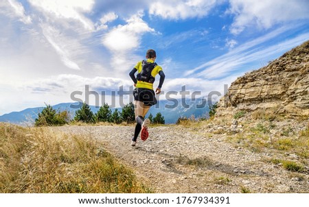 athlete runner run mountain trail marathon in background blue sky 