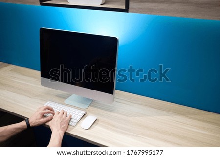 Office workplace with computer./ Modern creative workspace on blue wall.
