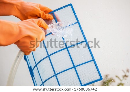 Asian man cleaning air conditioner dirty filter