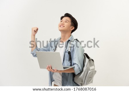 Winning asian college student with laptop in his hand isolated on white background