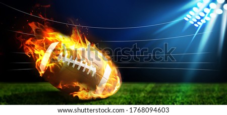 Leather American ball with flame on green football field. Banner design  