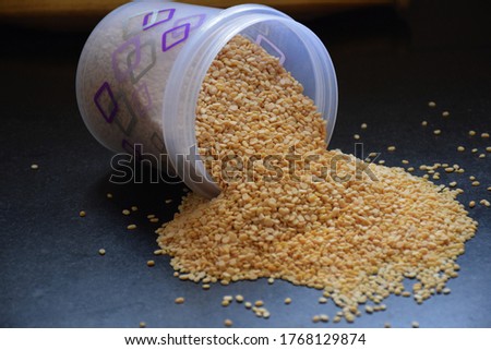 Stock photo organic fresh split yellow mung dal or yellow moong beans spread out on floor, Picture captured under natural light at Bangalore, Karnataka, India. focus on object, studio shoot.