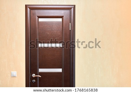 Wooden door in room, copy space. Closed interior door. Entrance to hotel apartment.