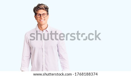 Young handsome man wearing business clothes and glasses with a happy and cool smile on face. lucky person. 