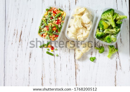 Healthy food is frozen. Stocks of food for the winter. Containers with frozen vegetables. Top view flat lay background. Copy space.