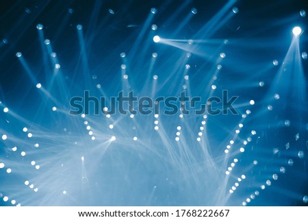 Defocused entertainment concert lighting on stage, blurred disco party background.