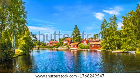 typical red swedish houses near by the pond Royalty-Free Stock Photo #1768249547