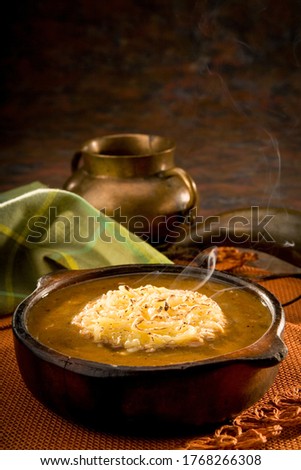 Bowl of onion soup with a napkin and a bowl in the background. Traditional Ecuadorian soup in a cozy and warm setup. Royalty-Free Stock Photo #1768266308