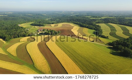 Aerial view of american countryside landscape, farmland. Drone flying over contrast rows of agricultural field. Rural scenery, farm. Sunny daytime, summer season Royalty-Free Stock Photo #1768278725