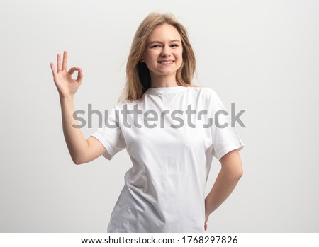 happy blonde young caucasian woman with hand gesture ok sign on white background.