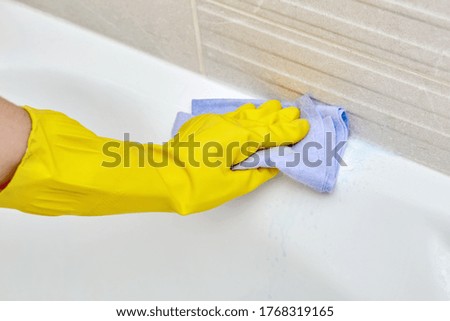 Professional housekeeping. Wash the bathroom. Yellow gloves for cleaning.