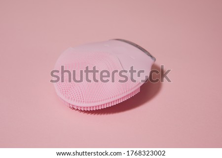 Silicone electric facial cleanser brush for skin care on pink background