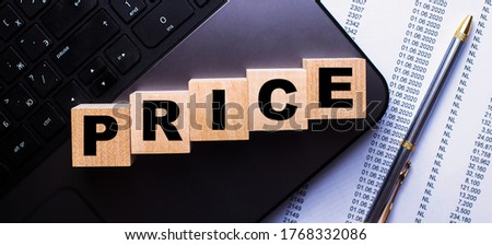 The word PRICE is written on wooden cubes that stand on the keyboard near the pen. Business concept