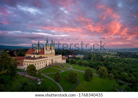 Aerial view on Pilgrimage Church of the Visitation of the Virgin Mary - pilgrimage site of European significance "The Holy Hill".Silhouette of basilica minor against pink evening clouds over landscape