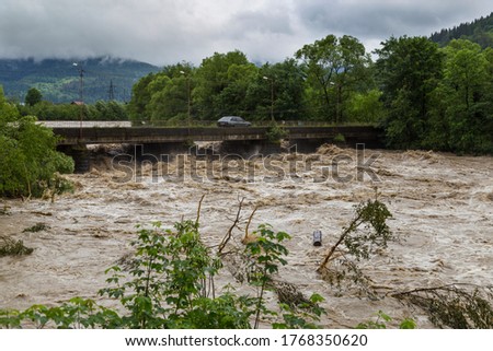 Wide fast stormy mountain river Prut flows under the bridge .  Natural disasters in the Carpathians village, Carpathian mountain. Ukraine