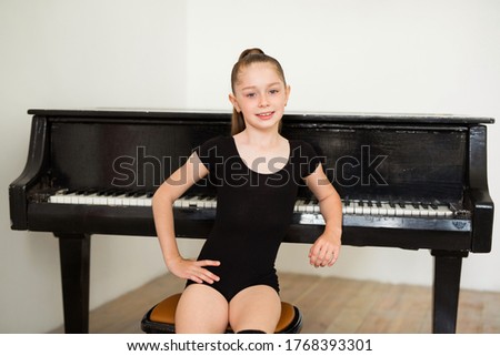 beautiful teen girl sitting near the piano