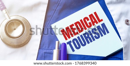 stethoscope, pens and note with text MEDICAL TOURISM on the doctor uniform