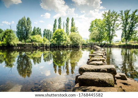 Ancient Roman stepping stones cross the Tâmega river in the city of Chaves. Portugal. Royalty-Free Stock Photo #1768445582