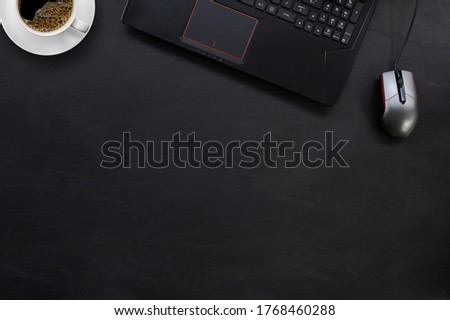 top view of office desk workspace with coffee cup and laptop  on black table background. flat lay