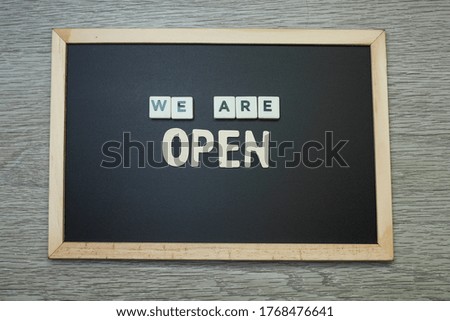 Black chalkboard with message on we are open 