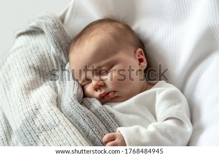 A close-up portrait of a baby girl who sleeps in a cradle or crib. Three-month-old girl sleeps sweetly. High quality photo Royalty-Free Stock Photo #1768484945