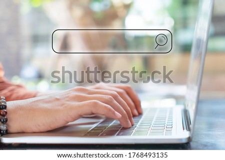 People hand using laptop or computor searching for information in internet online society web with search box icon and copyspace.