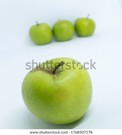 Close up view of green apples in a row isolated on a white background.