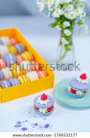 A set of pasta cakes lies on a stel next to a vase of flowers