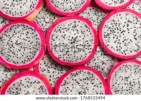 Sweet tasty dragon fruit or pitaya slices as a background.