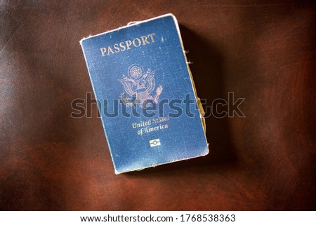 Old weathered American passport on leather background