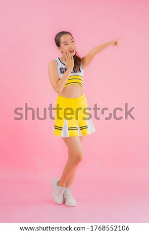 Portrait beautiful young asian woman cheerleader on pink isolated background