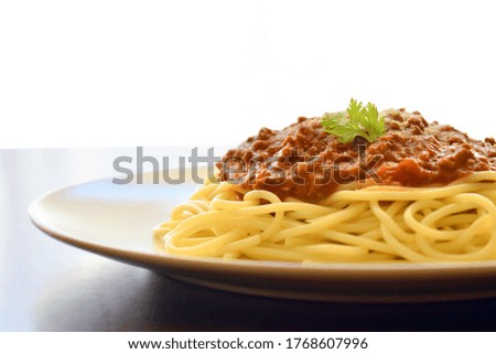 Spaghetti Bolognese with minced beef, onion, chopped tomato, garlic, olive oil, stock cube, tomato puree and Italian herb. Traditional Italian food. Copy space is on the left side.  Selective focus. 