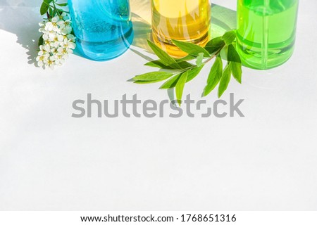 Gel green and blue, yellow oil for face care in glass bottles. leaves and flowers. Copy spase