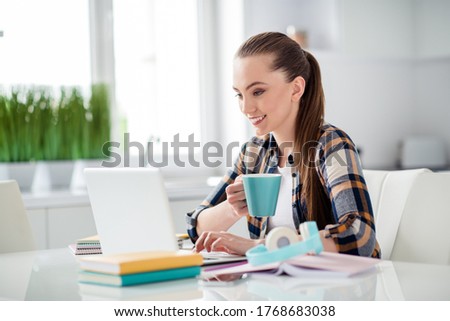 Photo of young pretty lady student browsing notebook sit desktop video call listen lesson online webinar conference education drink hot tea mug social distance quarantine indoors
