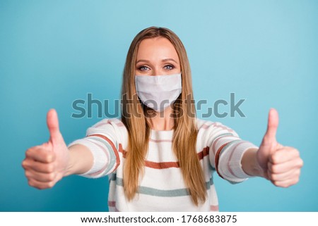 Close-up portrait of her she nice healthy girl wearing safety gauze mask giving two double thumbup mers cov influenza flu grippe recovery isolated bright vivid shine vibrant blue color background