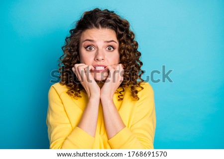 Close-up portrait of her she nice-looking attractive confused terrified worried scared wavy-haired girl watching scary movie biting nails isolated over bright vivid shine vibrant blue color background