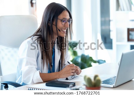 Shot of female doctor talking with colleagues through a video call with a laptop in the consultation. Royalty-Free Stock Photo #1768722701