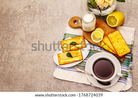 Healthy breakfast. Cup of coffee (black tea), milk, crackers with butter and salmon. Morning good mood, stone concrete background, top view