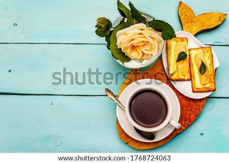 Healthy breakfast. Cup of coffee (black tea), milk, crackers with butter and salmon. Morning good mood, turquoise wooden background, top view