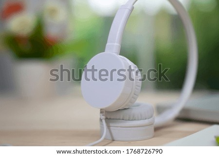 Headphones over laptop on wooden desk table. Music concept