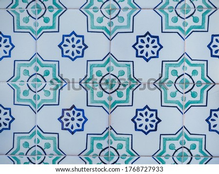 Fragment of building wall with colorful ceramic wall tiles, Azulejo close up. Abstract decorative background, textured ornate pattern for design or backdrop. Traditional ornate Portuguese architecture