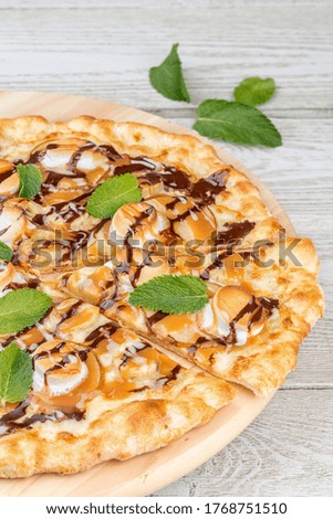 Sweet pizza poured with syrup and sliced one slice