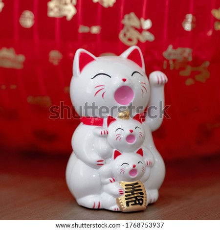 Close up Cute funny happy Maneki neko lucky cat , group cat and kittens show text on hand meaning rich on table