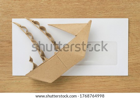 Origami paper sailboat mockup. Selective focus. Against the background of a white mail envelope.