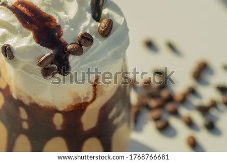 iced mocha coffee in front of a white background. cold coffee on the beach club in hot summer day. close up ice mocha with coffee beans.