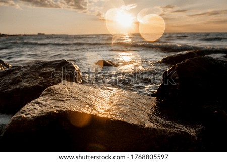 landscape of the sea at dawn, waves and splashes of water in the sun