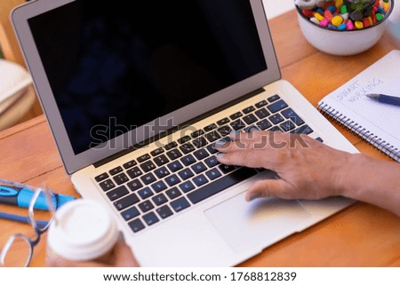 Senior woman hands typing on laptop keyboard,  tech and social people, wooden table with plant and coffee cup