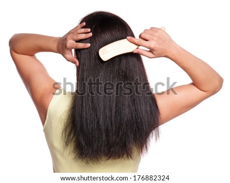 Picture of the back of a woman with long hair with hairbrush on white background